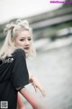 A woman with blonde hair leaning against a railing.