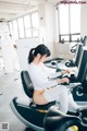 A woman sitting on a stationary bike in a gym.