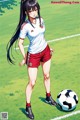 A woman standing next to a soccer ball on a field.