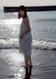 A woman standing in the water at the beach.