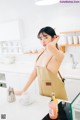 A woman standing in a kitchen next to a counter.